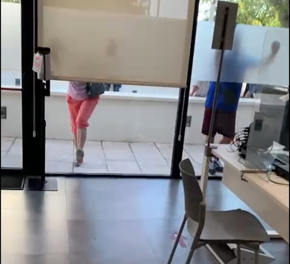 Varias personas golpean los cristales de la oficina con las piernas