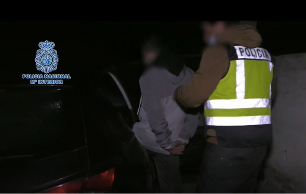 La Policía Nacional introduce en el coche a uno de los detenidos.