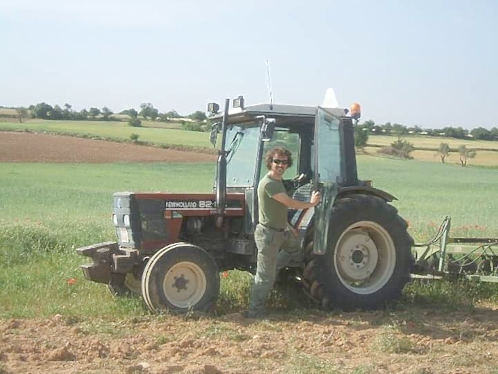 José Manuel durante el desarrollo de una tarea agrícola junto a su tractor.