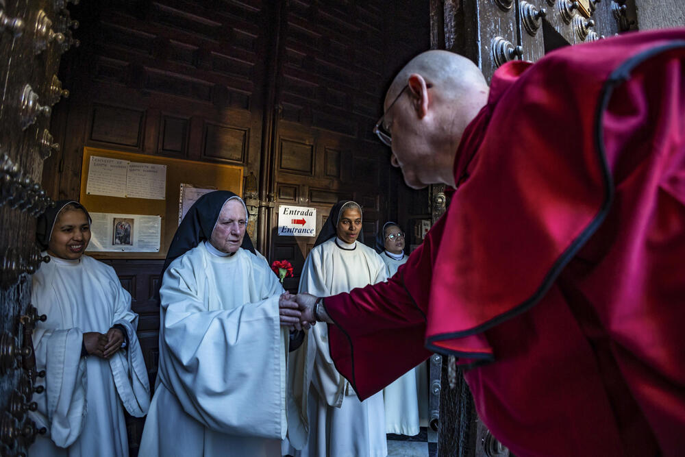 El capataz del Cristo de la Misericordia entrega un clavel del paso a una de las monjas de clausura del Santo Domingo el Antiguo.