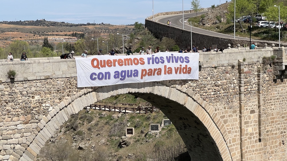 'Queremos ríos vivos con agua para la vida' es el eslogan de la manifestación que colgó del puente de Alcántara.